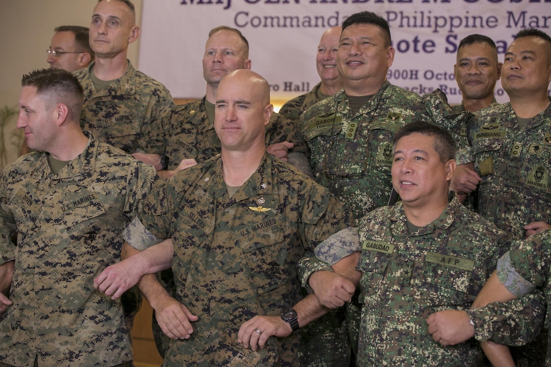 U.S. and Philippine Marines interlock arms in solidarity during the Philippine Amphibious Landing Exercise 33 (PHIBLEX) opening ceremony at Marine Barracks Rudiardo Brown, Taguig City, Philippines, Oct. 4, 2016. PHIBLEX is an annual U.S.-Philippine military bilateral exercise which combines amphibious capabilities and live-fire training with humanitarian civic assistance efforts to strengthen interoperability and working relationships. The U.S. Marines are with 3d Marine Expeditionary Brigade, III Marine Expeditionary Force. (U.S. Marine Corps photo by Cpl. Steven Tran/Released)