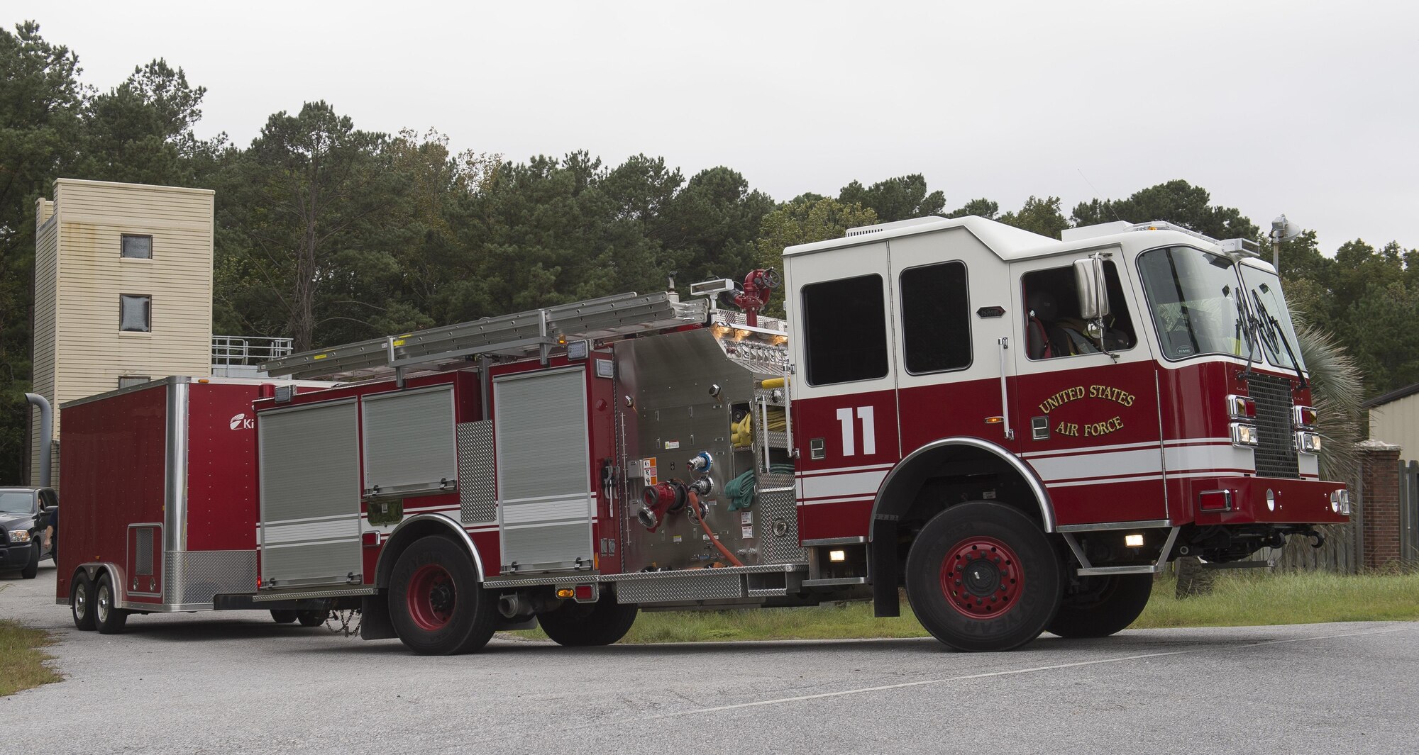 U.S. Air Force firefighters assigned to the 628th Civil Engineer Squadron move a trailer of training supplies to a more secure location in preparation of Hurricane Matthew at Joint Base Charleston, S.C., Oct. 6, 2016. All non-essential personnel evacuated the area, but will return after disaster response coordinators assess damage and verify a safe operating environment. (U.S. Air Force photo by Tech. Sgt. Barry Loo)