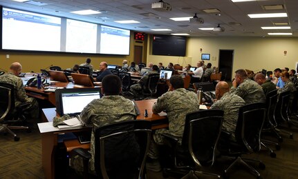 Mission essential personnel discuss ongoing operations at the Emergency Operations Center during Hurricane Condition I for Hurricane Matthew on Joint Base Charleston, S.C., Oct. 7, 2016. All non-essential personnel evacuated the area, but will return after disaster response coordinators assess damage and verify a safe operating environment. (U.S. Air Force photo by Senior Airman Nicholas Byers)