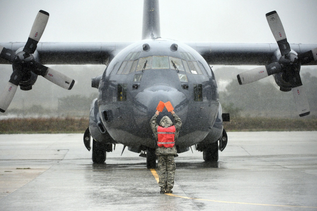 An airman flags to Air Force Lt. Col. John T. Law as he completes his final flight aboard an HC-130J Combat King II with the 106th Rescue Wing at Francis S. Gabreski Air National Guard Base in Westhampton Beach, N.Y., Sept. 30, 2016. He made the flight on the day of his retirement, following more than 24 years of service. Air National Guard photo by Staff Sgt. Christopher S. Muncy