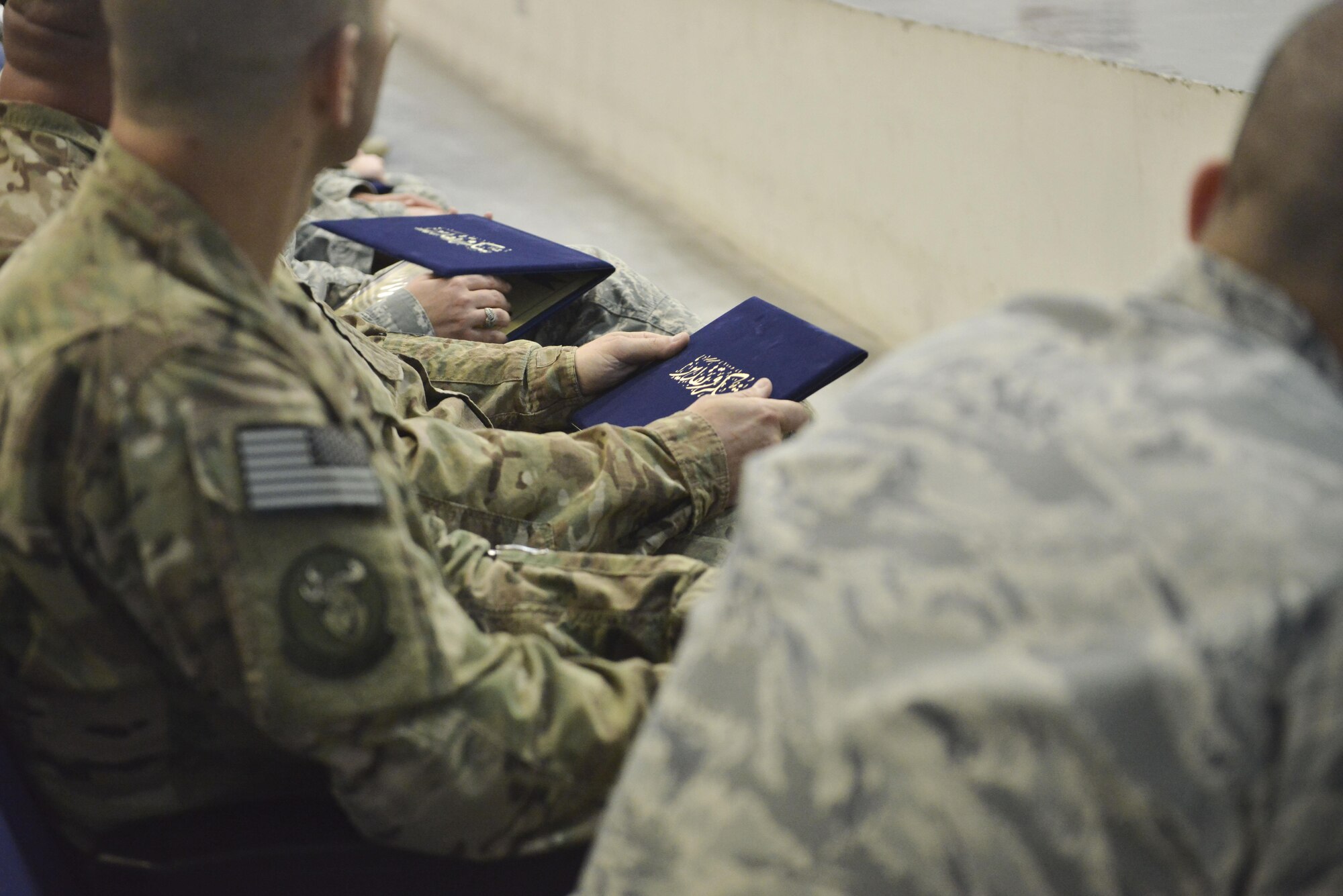 Graduates hold their Community College of the Air Force diplomas after a recognition ceremony April 28, 2015, at the Blatchford-Preston Complex Theater at Al Udeid Air Base, Qatar. Two graduations are held throughout the year here to better accommodate deployed members. Graduations are held annually across the Air Force. (U.S. Air Force photo/Staff Sgt. Alexandre Montes)