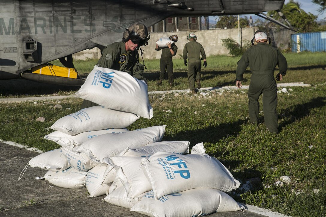 Marines unload bags of rice from a CH-53E Super Stallion in Les Cayes, Haiti, Oct. 7, 2016. The Marines are supporting Joint Task Force Matthew, which delivered more than 10,000 pounds of supplies on its first day of relief operations in the aftermath of Hurricane Matthew. Marine Corps photo by Cpl. Kimberly Aguirre