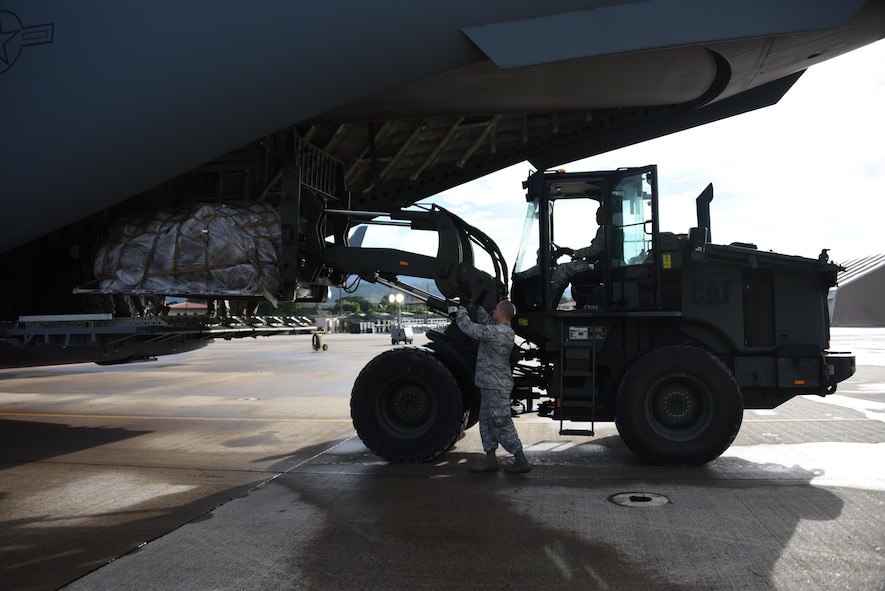 U.S. Air Force Staff Sgt. Dustin Jett, 612th Air Base Squadron senior information controller, guides a forklift driven by U.S. Air Force Staff Sgt. Jordan Woodard, 612th ABS information controller, into a C-17 Globemaster III cargo aircraft at Soto Cano Air Base, Honduras, with equipment destined for Port-au-Prince, Haiti to support Joint Task Force Matthew hurricane relief operations, Oct. 8, 2016. Extensive joint planning between Special Purpose Marine Air-Ground Task Force-Southern Command and JTF-Bravo logistics personnel was required to establish load plans and cargo prioritization so the equipment would be ready to load and transport without delay to prevent any mission stoppages or shortfalls. (U.S. Air Force photo by Capt. David Liapis)