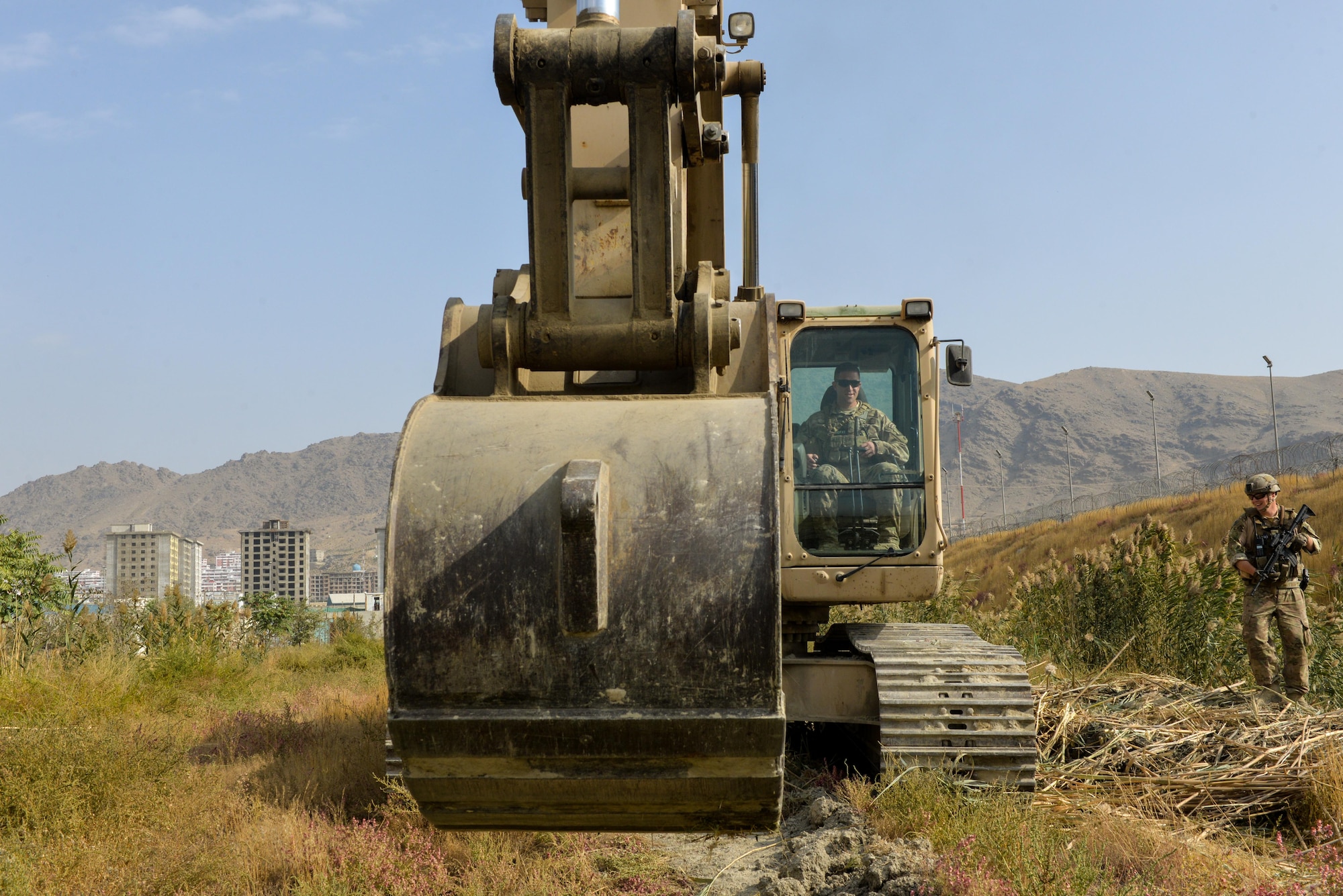 Master Sgt. Thomas Ryan, Train, Advise, Assist Command-Air (TAAC-Air) civil engineer advisor, starts an excavator before clearing reeds in a field at Kabul Air Wing, Afghanistan, Oct. 6, 2016. The excavator was loaned to TAAC-Air by the Afghan Air Force civil engineer squadron so that the area could be cleared of reeds that were preventing security forces members manning an entry control point from having a clear view of their surrounding area. (U.S. Air Force photo by Tech. Sgt. Christopher Holmes)