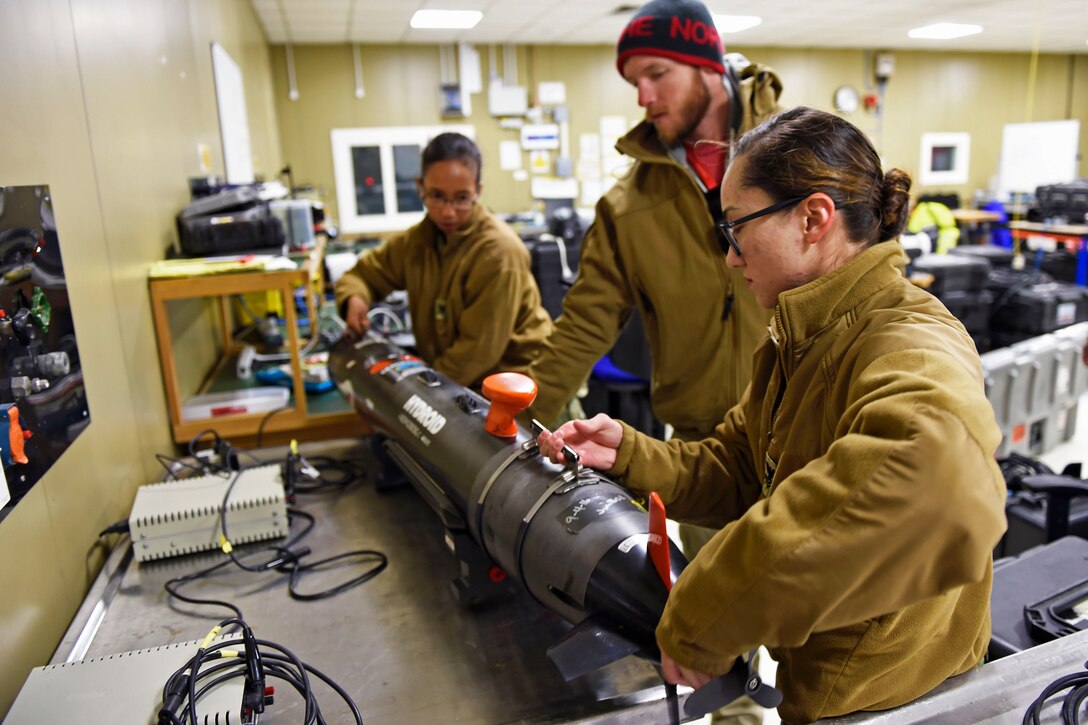 Navy Petty Officer 2nd Class Tammy Helm, right, Navy Petty Officer 3rd Class Erica Equaling and Cody Brashears assigned to the Naval Oceanography Mine Warfare Center move a remote environmental measuring units, or REMUS,100 during the first-ever Unmanned Warrior research and training exercise designed to test and demonstrate the latest in autonomous naval technologies while strengthening international interoperability in Lochalsh, U.K.,  Oct. 9, 2016. Navy photo by John F. Williams