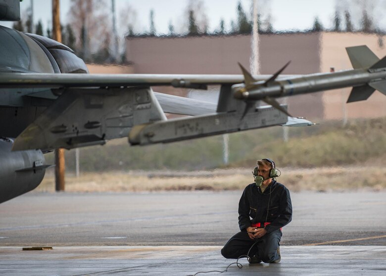 U.S. Air Force Airman 1st Class Spencer Hall, a 354th Aircraft Maintenance Squadron crew chief, conducts last checks on an F-16 Fighting Falcon aircraft, while Col. David Mineau, the 354th Fighter Wing commander, prepares to fly for a sortie Oct. 10, 2016, for RED FLAG-Alaska at Eielson Air Force Base, Alaska. More than 60 aircraft and hundreds of participants from partnering units around the world will participate in the Pacific Air Forces commander-directed exercise. (U.S. Air Force photo by Staff Sgt. Shawn Nickel)
