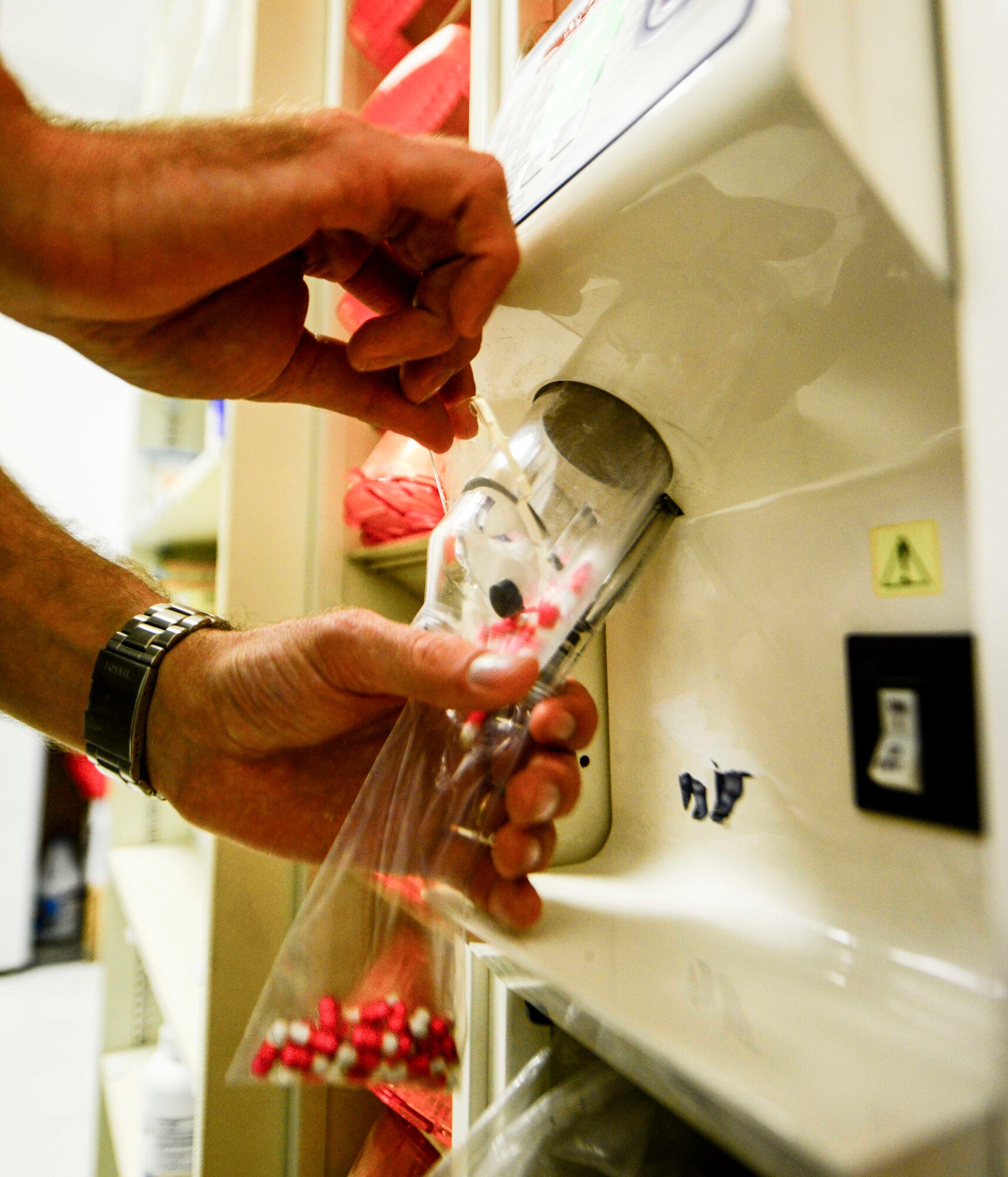 Senior Airman Timothy Di Donato, 379th Expeditionary Civil Engineer Squadron force protection escort, pours prescribed medicine into a bag Oct. 4, 2016, at Al Udeid Air Base, Qatar. Di Donato, a pharmacy technician at Tyndall Air Force Base, Fla., volunteers to assist the pharmacy on base. Pharmaceutical care extends to the coalition military forces, retirees, Department of Defense civilian employees and contract employees who have been verified through the Synchronized Pre-deployment and Operational Tracker by patient administration. (U.S. Air Force photo/Senior Airman Janelle Patiño/Released)