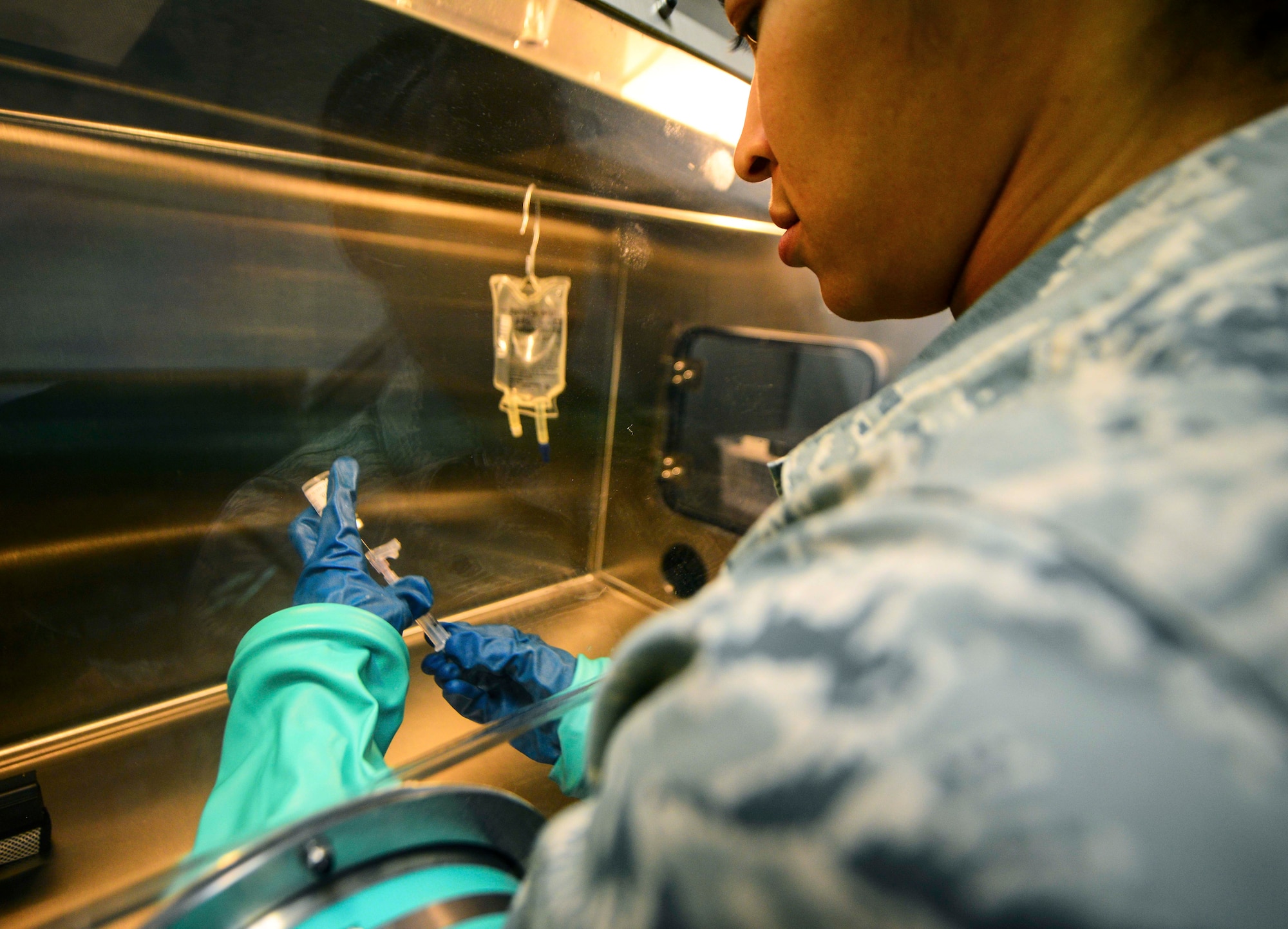 Staff Sgt. Marckia Wilson, 379th Expeditionary Medical Support Squadron pharmacy technician, prepares an intravenous injection to be administered to a patient on the inpatient care ward Oct. 4, 2016, at Al Udeid Air Base, Qatar. Pharmacists and technicians are responsible for ensuring appropriate critical care medications are made using aseptic techniques in the IV hood. (U.S. Air Force photo/Senior Airman Janelle Patiño/Released)