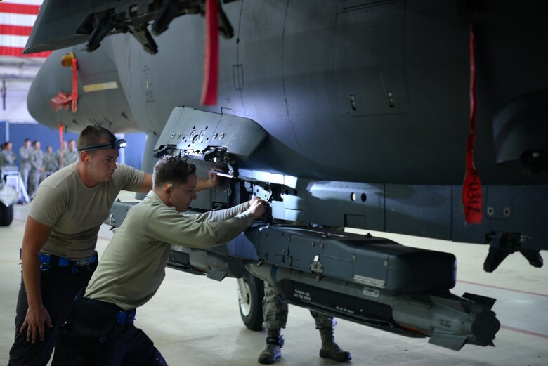 U.S. Air Force Senior Airman Connor Borah, left, and U.S. Air Force Jeremy Moore, right, 492nd Aircraft Maintenance Unit weapons load crew team members, load ammunition onto an F-15E Strike Eagle at Royal Air Force Lakenheath, England, Oct. 6. The ammunition was loaded as part of a quarterly load crew competition. The 48th Maintenance Group holds the competitions to give Airmen a chance to show off their technical prowess to peers and wing leadership. 
