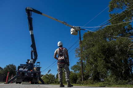 U.S. Air Force Senior Airmen Robert Aguilar and Casey Cooper, electrician linemen with the 628th Civil Engineer Squadron, repair electrical lines after  Hurricane Mathew swept through Joint Base Charleston, S.C., Oct. 9, 2016.  All non-essential personnel evacuated the area, but returned after disaster response coordinators assessed damage and verified a safe operating environment. 