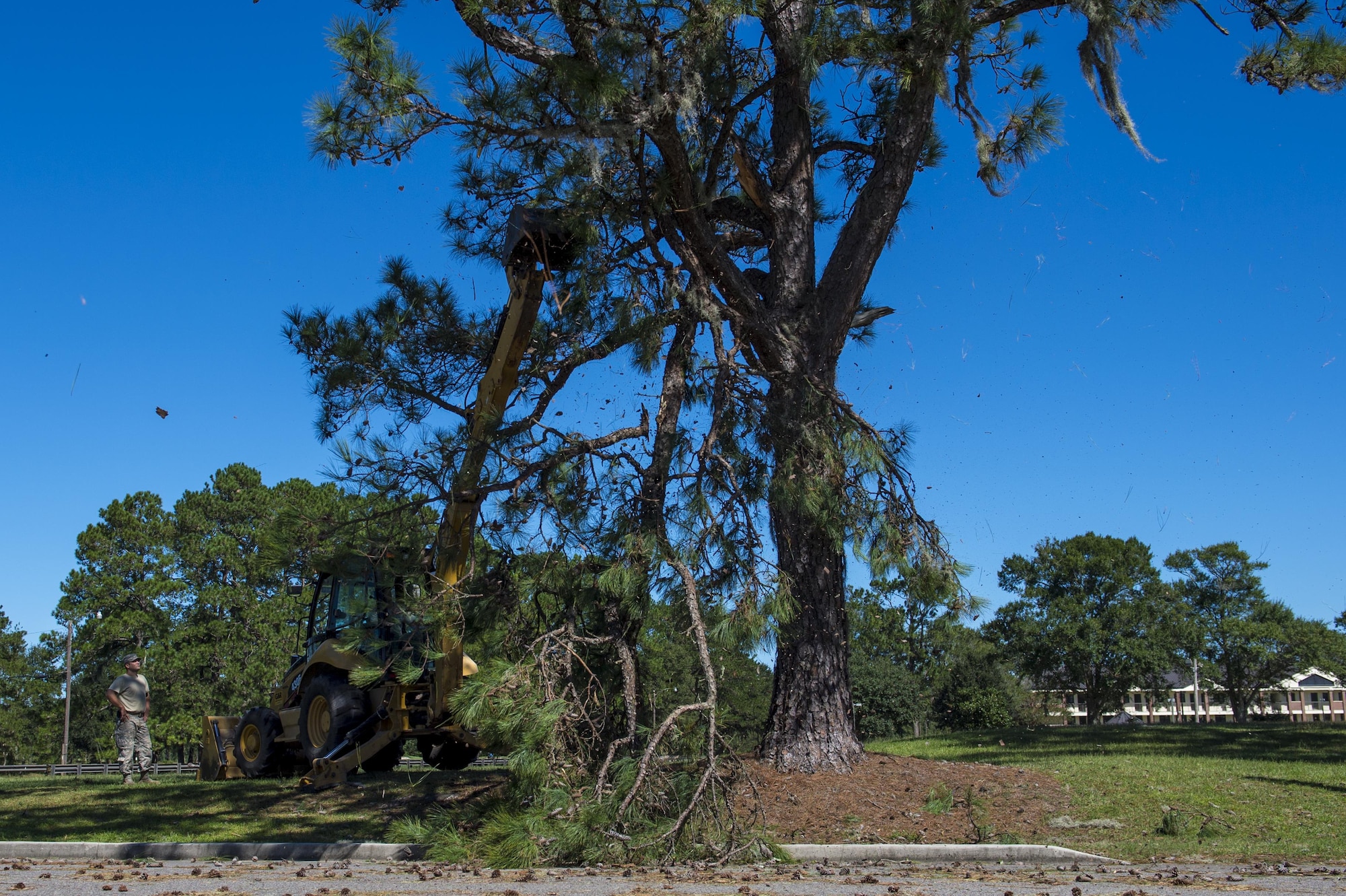 U.S. Air Force Master Sgt. Chris Moffett and Senior Airman Jesse Steinberg, heavy equipment operators with the 628th Civil Engineer Squadron, tear down broken tree limbs after  Hurricane Mathew swept through Joint Base Charleston, S.C., Oct. 9, 2016.  All non-essential personnel evacuated the area, but returned after disaster response coordinators assessed damage and verified a safe operating environment. 