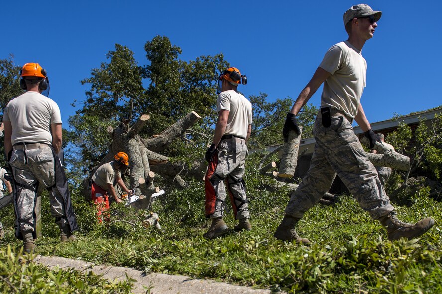 U.S. Air Force civil engineers with the 628th Civil Engineer Squadron, remove a fallen tree after  Hurricane Mathew swept through Hunley Park-Air Base housing, S.C., Oct. 9, 2016.   All non-essential personnel evacuated the area, but returned after disaster response coordinators assessed damage and verified a safe operating environment. 