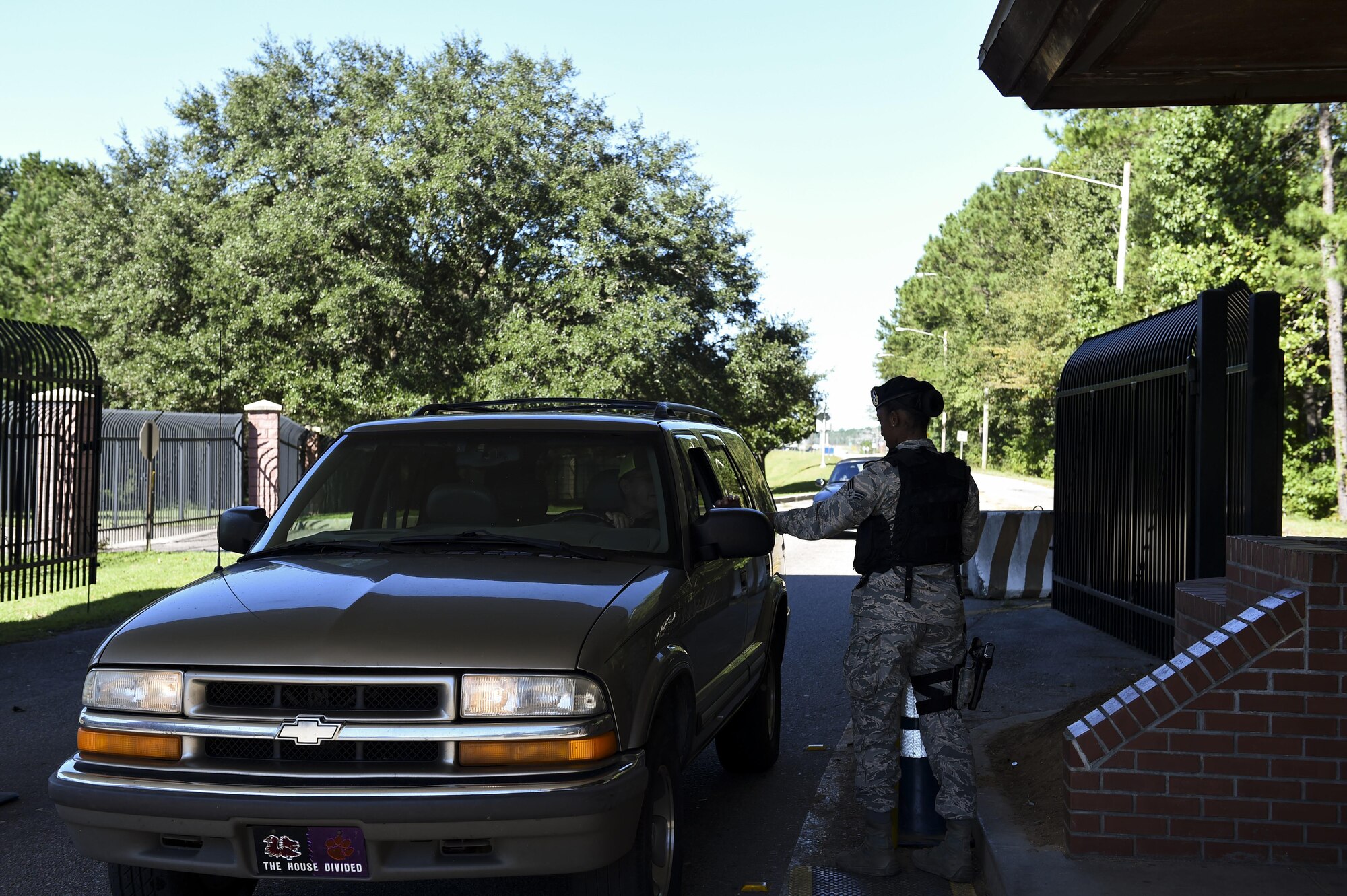 U.S. Air Force Senior Airman Jasmine Jamison, a patrol officer with the 628th Security Forces Squadron, checks the identification of those entering the gates after Hurricane Matthew swept the area on Joint Base Charleston - Naval Weapons Station, S.C., Oct. 9, 2016. All non-essential personnel evacuated the area, but returned after disaster response coordinators assessed damage and verified a safe operating environment. 