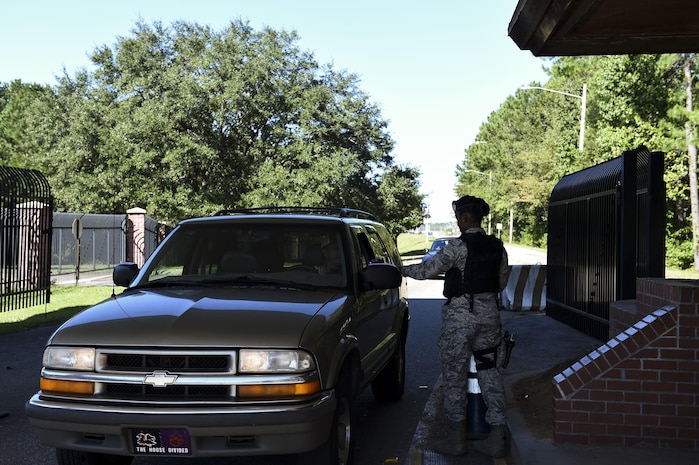 U.S. Air Force Senior Airman Jasmine Jamison, a patrol officer with the 628th Security Forces Squadron, checks the identification of those entering the gates after Hurricane Matthew swept the area on Joint Base Charleston - Naval Weapons Station, S.C., Oct. 9, 2016. All non-essential personnel evacuated the area, but returned after disaster response coordinators assessed damage and verified a safe operating environment. 