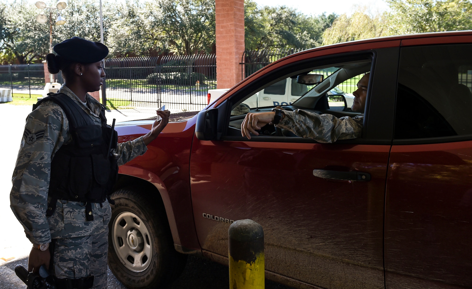 U.S. Air Force Senior Airman Jasmine Jamison, a patrol officer with the 628th Security Forces Squadron, checks the identification of those entering the gates after Hurricane Matthew swept the area on Joint Base Charleston - Naval Weapons Station, S.C., Oct. 9, 2016. All non-essential personnel evacuated the area, but returned after disaster response coordinators assessed damage and verified a safe operating environment. 