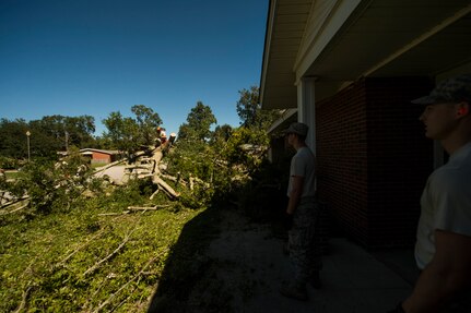 U.S. Air Force civil engineers with the 628th Civil Engineer Squadron remove fallen trees on Hunley Park-Air Base housing done by Hurricane Matthew on Joint Base Charleston, S.C., Oct. 9, 2016. All non-essential personnel evacuated the area, but returned after disaster response coordinators assessed damage and verified a safe operating environment. 