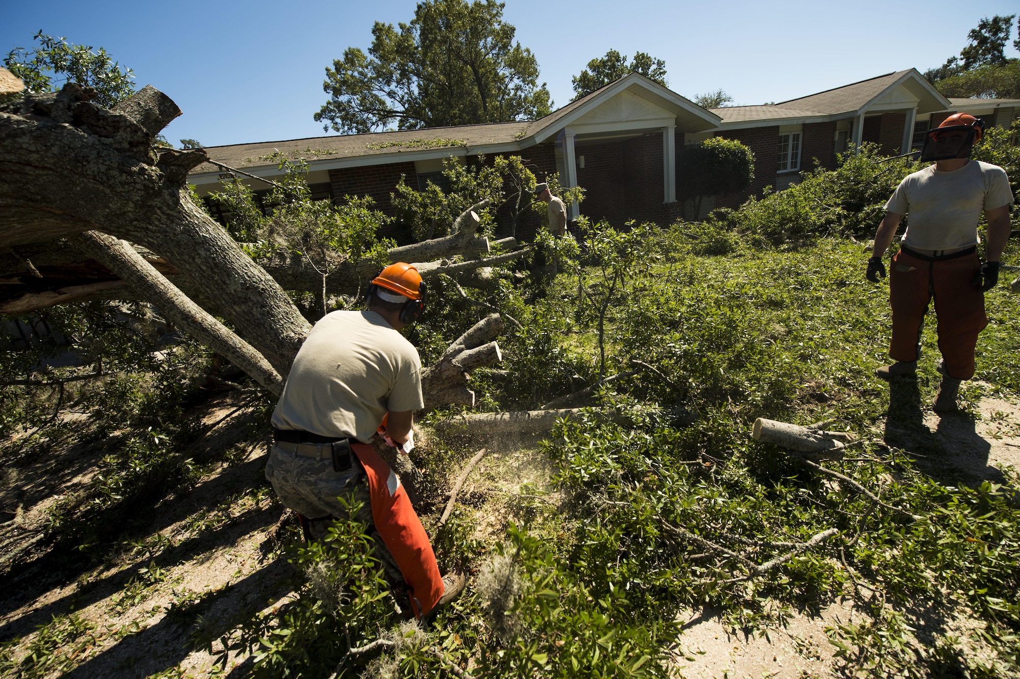 U.S. Air Force civil engineers with the 628th Civil Engineer Squadron remove fallen trees on Hunley Park-Air Base housing done by Hurricane Matthew on Joint Base Charleston, S.C., Oct. 9, 2016. All non-essential personnel evacuated the area, but returned after disaster response coordinators assessed damage and verified a safe operating environment. 