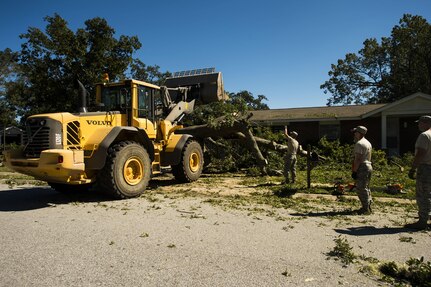 U.S. Air Force civil engineers with the 628th Civil Engineer Squadron use a front-end loader to remove fallen trees on Hunley Park-Air Base housing done by Hurricane Matthew on Joint Base Charleston, S.C., Oct. 9, 2016. All non-essential personnel evacuated the area, but returned after disaster response coordinators assessed damage and verified a safe operating environment. 