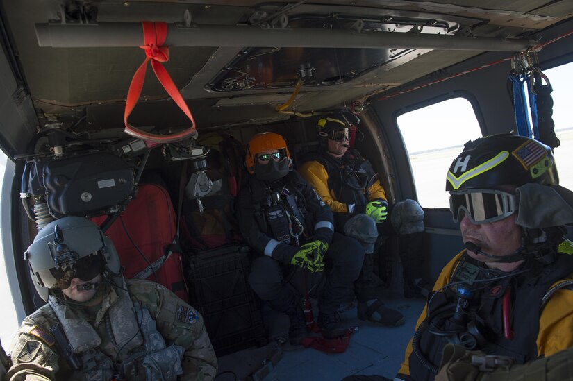 From left, U.S. Army Sgt. Dustin Keenan, a flight medic assigned to 2nd Battalion, 151st Brigade, South Carolina National Guard, Kevin Hollister, South Carolina Helicopter Aquatic Rescue Team, Joel Koricick, and Scott Grahn, both with the Pennsylvania Helicopter Aquatic Rescue Team, prepare to conduct a damage assessment flight onboard an Army UH-60 Blackhawk over Joint Base Charleston, S.C., after Hurricane Matthew swept the area Oct. 9, 2016. All non-essential personnel evacuated the area, but returned after disaster response coordinators assessed damage and verified a safe operating environment. 