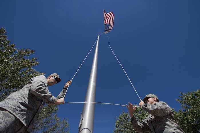 U.S. Air Force Lt. Col. Matthew Brennan, left, the commander of the 628th Civil Engineer Squadron, and Maj. Abbillyn Johnson, the commander of the 628th Logistics Readiness Squadron, raise the base flag over Joint Base Charleston, S.C., after Hurricane Matthew swept the area Oct. 9, 2016. All non-essential personnel evacuated the area, but returned after disaster response coordinators assessed damage and verified a safe operating environment. 