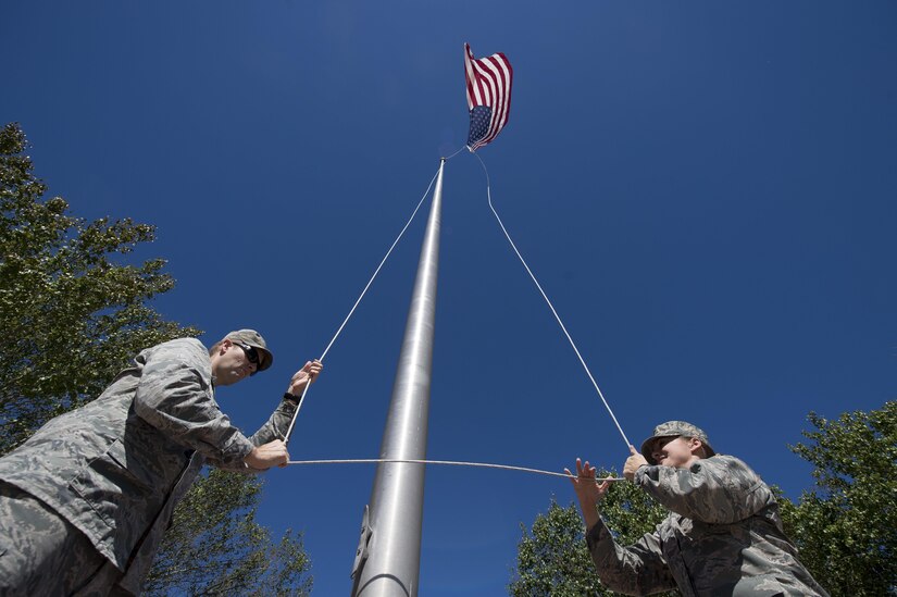 U.S. Air Force Lt. Col. Matthew Brennan, left, the commander of the 628th Civil Engineer Squadron, and Maj. Abbillyn Johnson, the commander of the 628th Logistics Readiness Squadron, raise the base flag over Joint Base Charleston, S.C., after Hurricane Matthew swept the area Oct. 9, 2016. All non-essential personnel evacuated the area, but returned after disaster response coordinators assessed damage and verified a safe operating environment. 