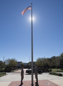 U.S. Air Force Maj. Abbillyn Johnson, left, the commander of the 628th Logistics Readiness Squadron, and Lt. Col. Matthew Brennan, the commander of the 628th Civil Engineer Squadron, raise the base flag over Joint Base Charleston, S.C., after Hurricane Matthew swept the area Oct. 9, 2016. All non-essential personnel evacuated the area, but returned after disaster response coordinators assessed damage and verified a safe operating environment. 
