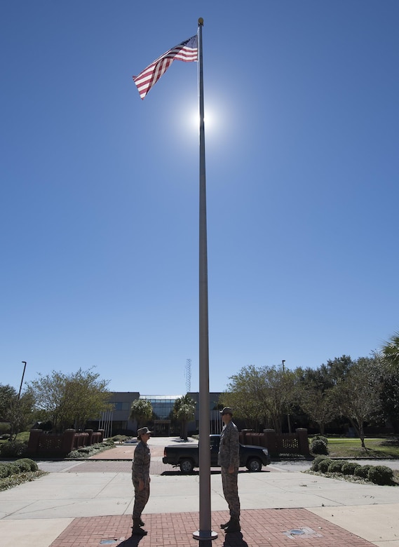 U.S. Air Force Maj. Abbillyn Johnson, left, the commander of the 628th Logistics Readiness Squadron, and Lt. Col. Matthew Brennan, the commander of the 628th Civil Engineer Squadron, raise the base flag over Joint Base Charleston, S.C., after Hurricane Matthew swept the area Oct. 9, 2016. All non-essential personnel evacuated the area, but returned after disaster response coordinators assessed damage and verified a safe operating environment. 