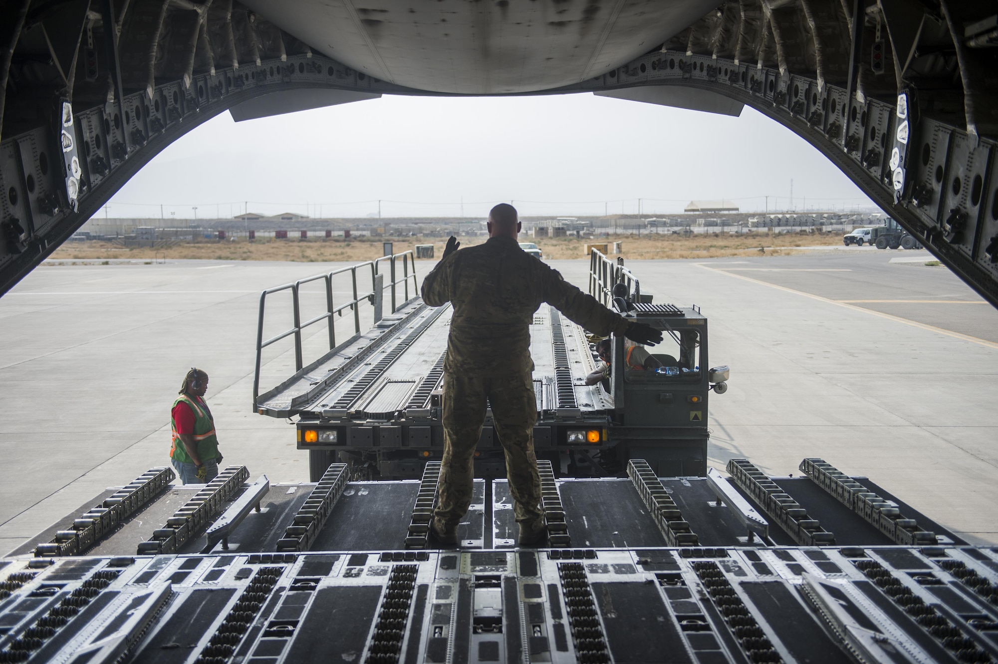 A U.S. Air Force C-17 Globemaster III loadmaster directs a loading truck during a transport mission in support of Operation Freedom Sentinel in Southwest Asia Sept. 30, 2016. The C-17 is the newest most flexible cargo aircraft to enter the airlift force. The C-17 is capable of rapid strategic delivery of troops and all types of cargo to main operating bases or directly to forward bases in the deployment area. (U.S. Air Force photo by Staff Sgt. Douglas Ellis/Released)