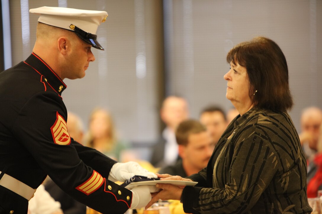 Staff Sgt. Christian Wolanski, a recruiter at Recruiting Station St. Louis, delivers a flag to a Gold Star mother at the 7th Annual Gold Star Family Luncheon on Oct. 1, 2016 in St. Louis, Mo. The term "Gold Star" refers to a family who lost a loved one in war. (U.S. Marine Corps photo by Cpl. Jennifer Webster/Released)