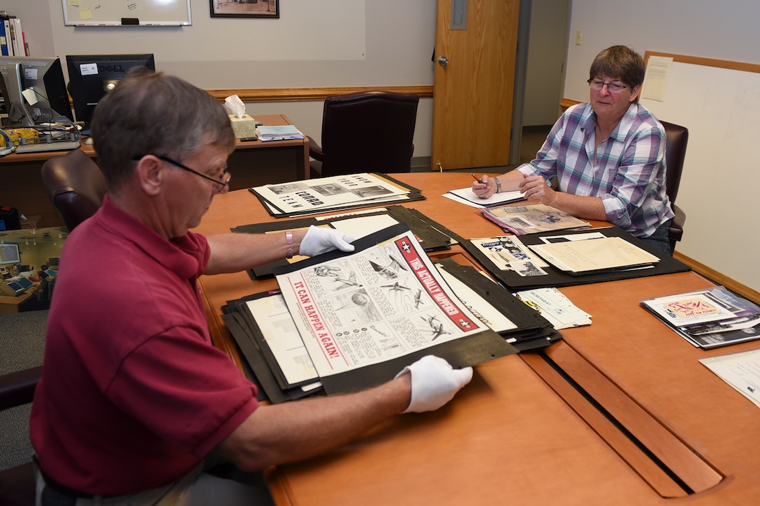 PETERSON AIR FORCE BASE, Colo. – Jeffrey Nash, Peterson Air and Space Museum assistant director, and Gail Whalen, Peterson Air and Space Museum director, inventory a potential donation of graphic works at Peterson Air Force Base, Colo., Oct. 3, 2016. The graphic was created by Paul S. Jaffe, who was the lead graphic artist and cartoonist for the Air Defense Command and North American Aerospace Defense Command in the 1950s and early 60s.  Jaffe designed the original NORAD emblem that is still used today. (U.S. Air Force photo by Philip Carter)