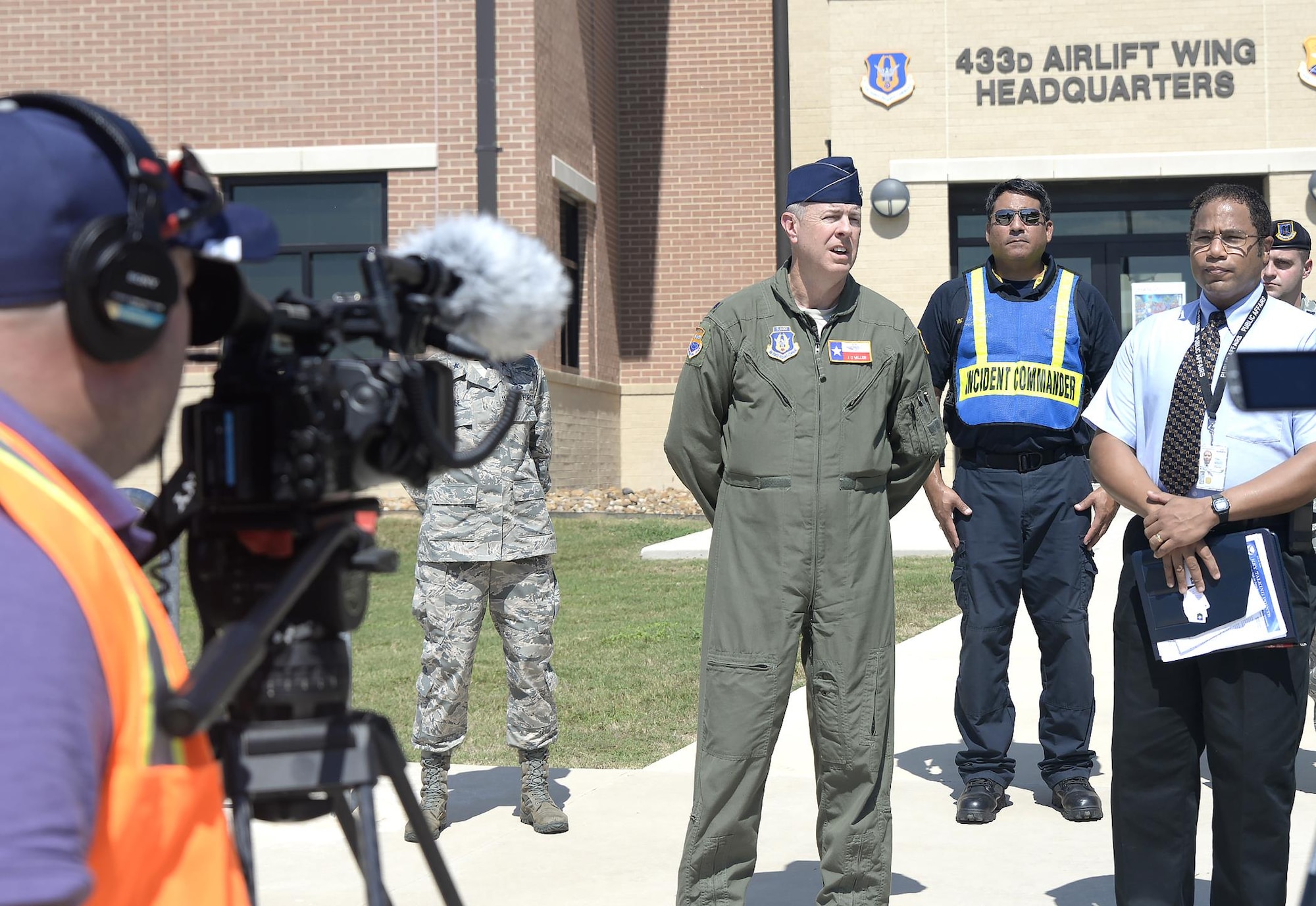 Lt.Col. James Miller, 433rd Operations Group deputy commander, answers questions from the media at a mock press conference Oct. 5, 2016 at Joint Base San Antonio-Lackland, Texas. The 502nd Air Base Wing, 433rd Airlift Wing, and 59th Medical Wing held a joint anti-hijacking exercise to evaluate emergency services reaction time to a real-world hijacking scenario. (U.S. Air Force photo by Benjamin Faske)