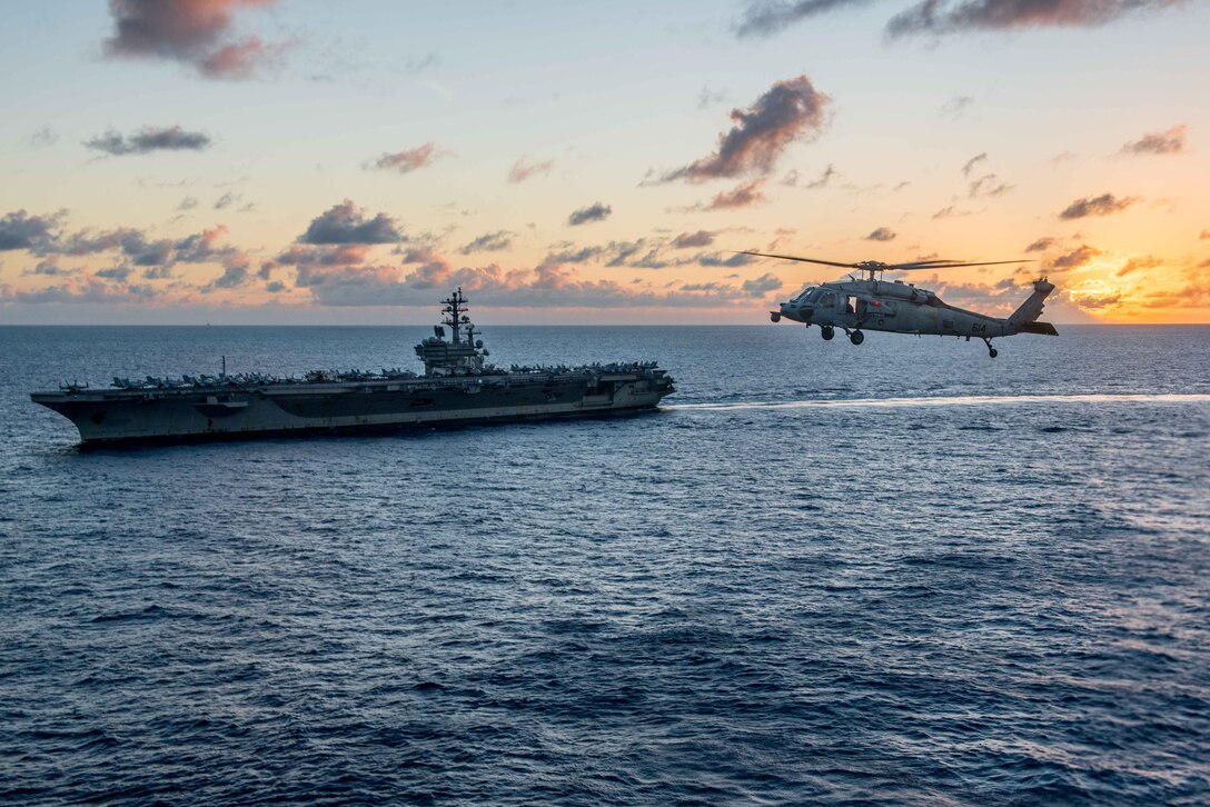 An MH-60S Sea Hawk, assigned to the Golden Falcons of Helicopter Sea Combat Squadron, flies near the Navy's only forward-deployed aircraft carrier, USS Ronald Reagan during helicopter search-and-rescue training in the Philippine Sea, Oct. 7, 2016.

