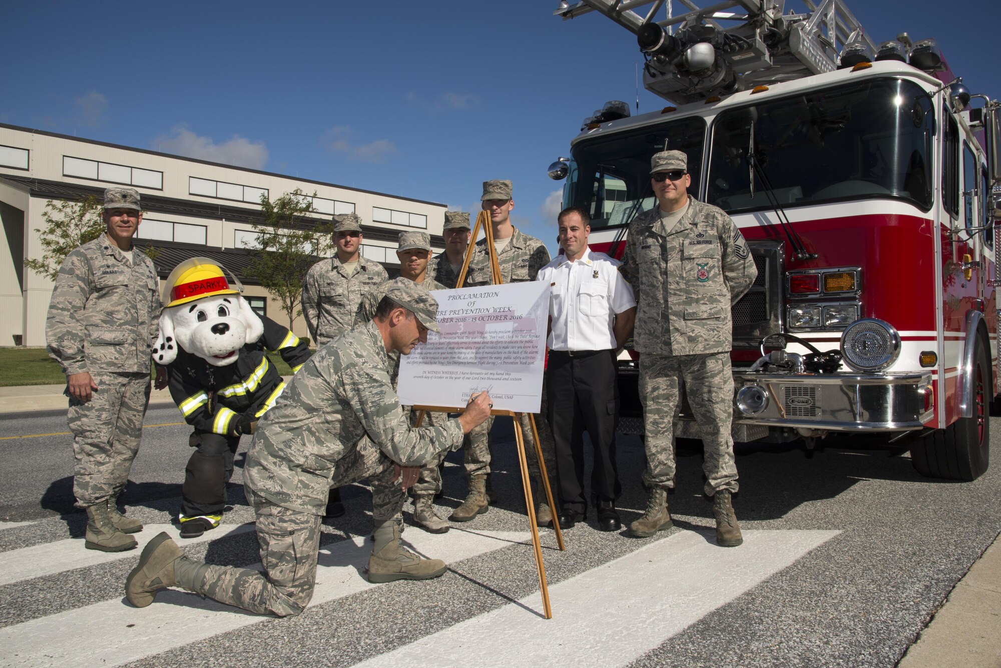 Col. Ethan Griffin, 436th Airlift Wing commander, signs the 2016 Fire Prevention Week proclamation with members from the 436th Civil Engineer Squadron Fire Department Oct. 6, 2016, at Dover Air Force Base, Del. Each year, the wing commander signs a proclamation declaring the installation’s intent to educate Team Dover about fire prevention. (U.S. Air Force photo by Senior Airman Aaron J. Jenne)