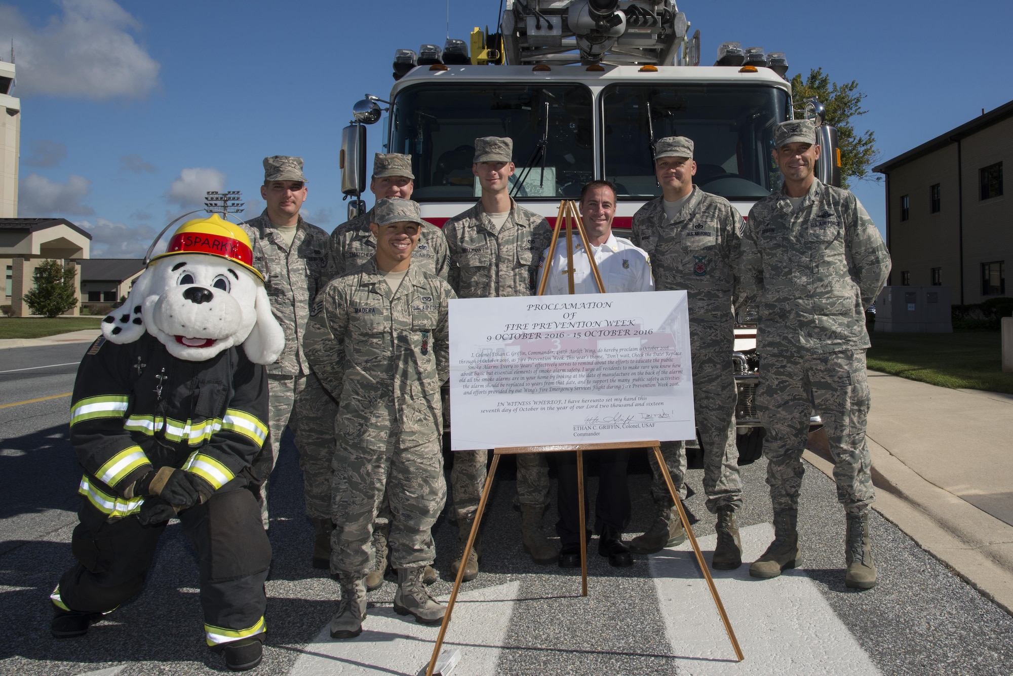 Col. Ethan Griffin, 436th Airlift Wing commander, and members from the 436th Civil Engineer Squadron Fire Department stand behind the signed Fire Prevention Week proclamation Oct. 6, 2016, at Dover Air Force, Del. The department will be hosting a fire muster, open house and a blood drive as well as book reading sessions with Sparky the Fire Dog at the Child Development Center and Youth Center. (U.S. Air Force photo by Senior Airman Aaron J. Jenne)