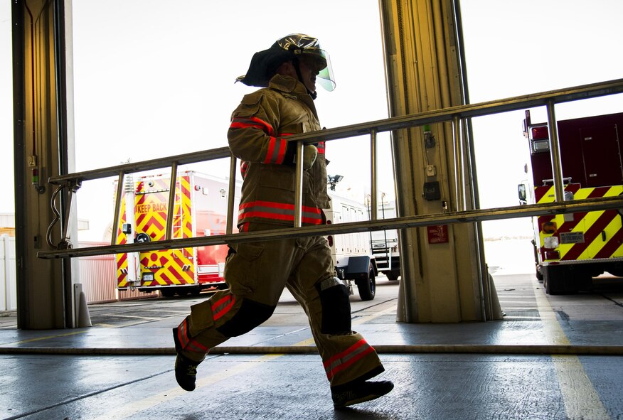 An officer carries a ladder during the firefighter fitness competition Oct. 11 at Eglin Air Force Base, Fla.  The competition pitted base enlisted and officer leadership in a duel for the best time to complete six firefighter fitness events.  The Eagles claimed victory over the Chiefs and first sergeants took the win over the squadron commanders.  (U.S. Air Force photo/Samuel King Jr.)