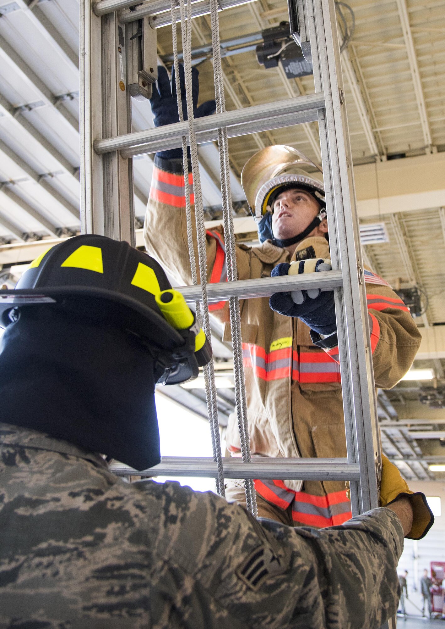 An Airman begins the ladder climb during the firefighter fitness competition Oct. 11 at Eglin Air Force Base, Fla.  The competition pitted base enlisted and officer leadership in a duel for the best time to complete six firefighter fitness events.  The Eagles claimed victory over the Chiefs and first sergeants took the win over the squadron commanders.  (U.S. Air Force photo/Samuel King Jr.)