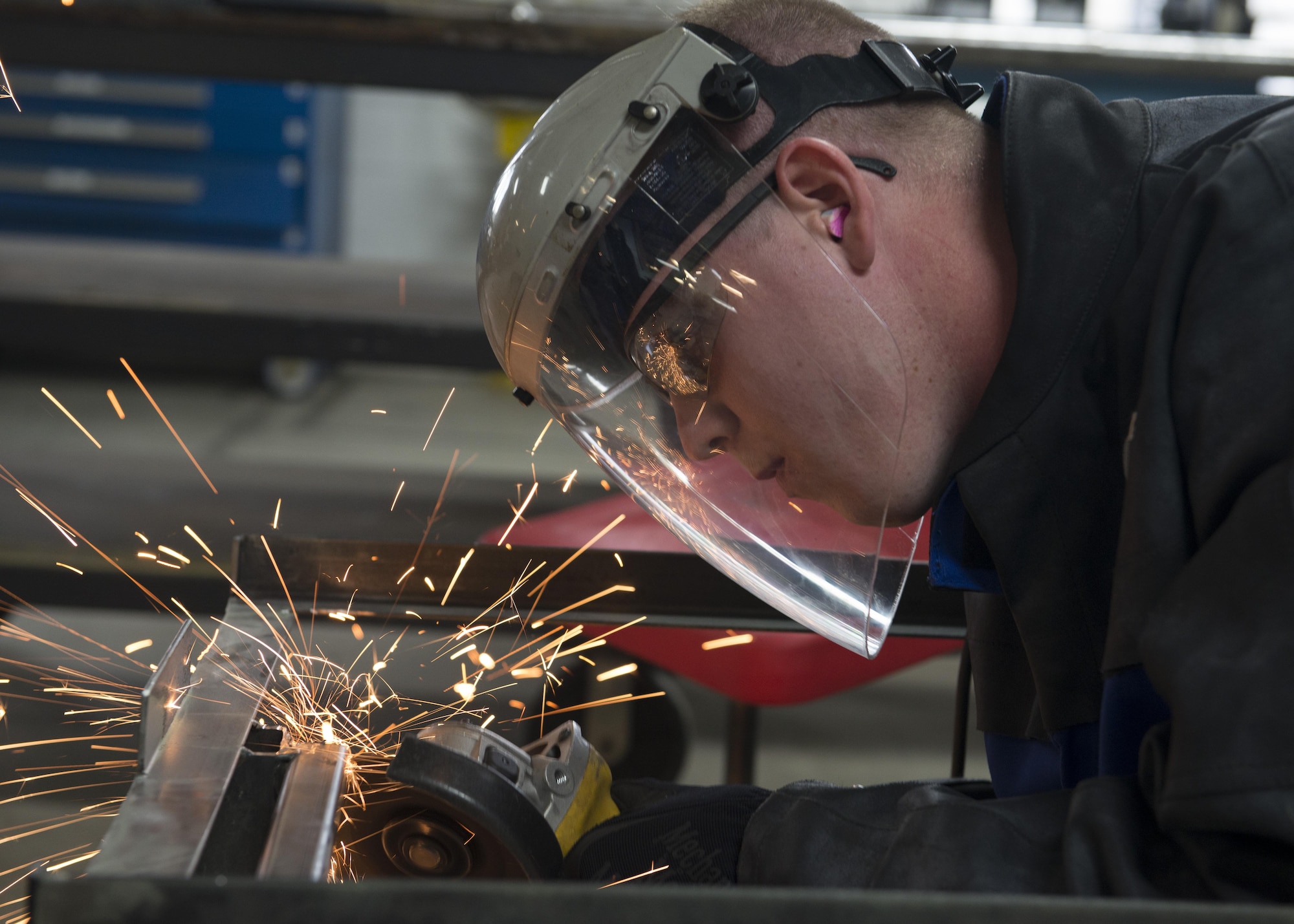 Senior Airman Cory Swan, 512th Maintenance Squadron metals technician, uses an angle grinder to remove a piece of metal from a metal frame Sept. 19, 2016, at Dover Air Force Base, Del. The Aircraft Metals Technology Shop worked hand-in-hand with the Air Force Mortuary Affairs Operations to ensure the success of the dignified transfer mission by designing and fabricating a custom frame for AFMAO’s new transfer vehicles. (U.S. Air Force photo by Senior Airman Zachary Cacicia)