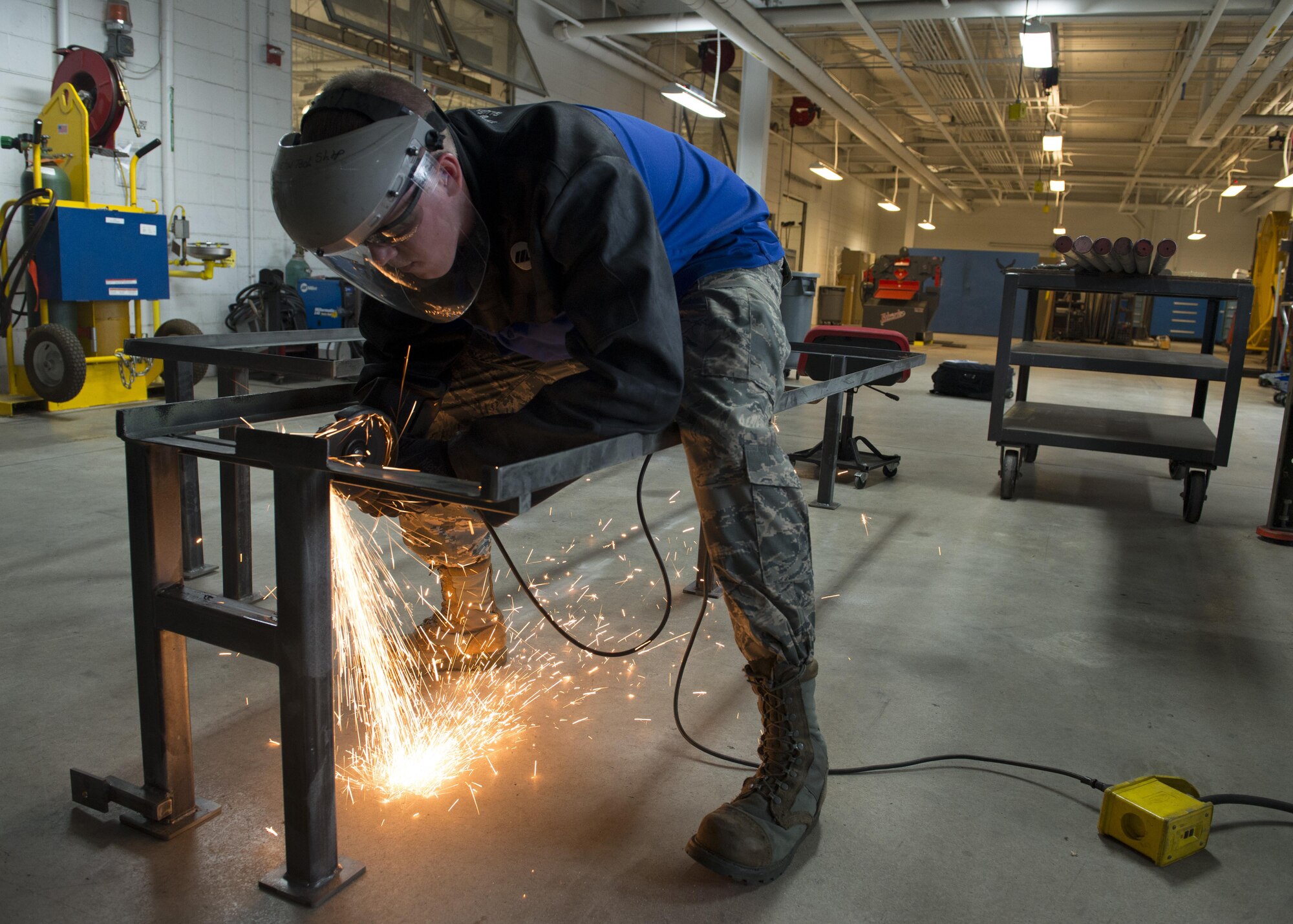 Senior Airman Cory Swan, 512th Maintenance Squadron metals technician, uses an angle grinder to remove a piece of metal from a metal frame Sept. 19, 2016, at Dover Air Force Base, Del. The Metals Technology Shop supported the Air Force Mortuary Affairs Operations mission by designing and building frames for their new transfer vehicles. (U.S. Air Force photo by Senior Airman Zachary Cacicia)