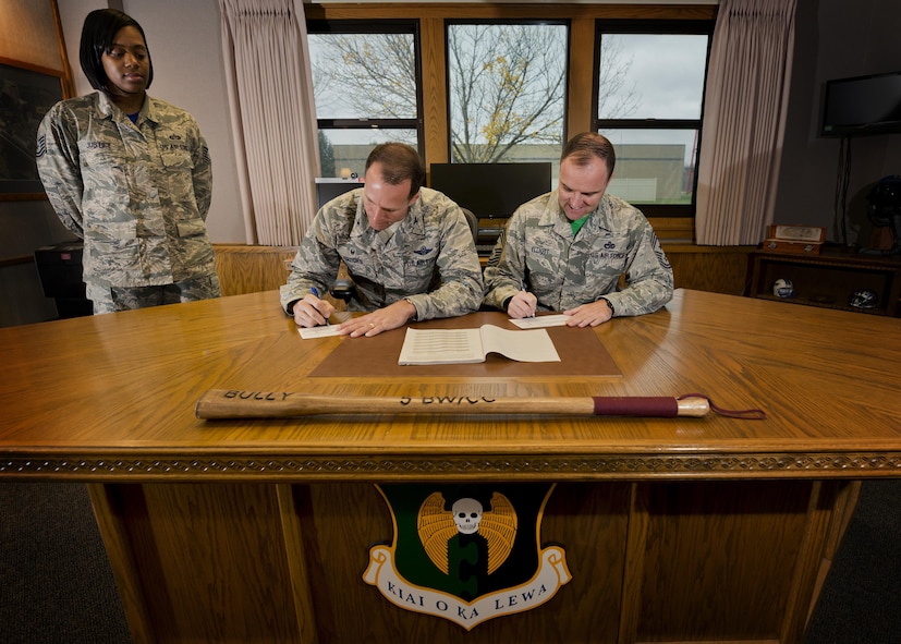 (From left) Tech Sgt. Cornelia Justice, 5th Bomb Wing staff judge advocate NCO in charge of military justice and Combined Federal Campaign representative, watches Col. Matthew Brooks, 5th BW commander, and Chief Master Sgt. Paul Elliott, 5th BW command chief, donate to the Combined Federal Campaign at Minot Air Force Base, N.D., Oct. 7, 2016. In 2015, the total amount contributed by both military and civilian donors in Minot AFB was $110,000. This year, Team Minot's campaign runs until Oct. 22, 2016, with a goal of $125,000. (U.S. Air Force photo/Airman 1st Class J.T. Armstrong)