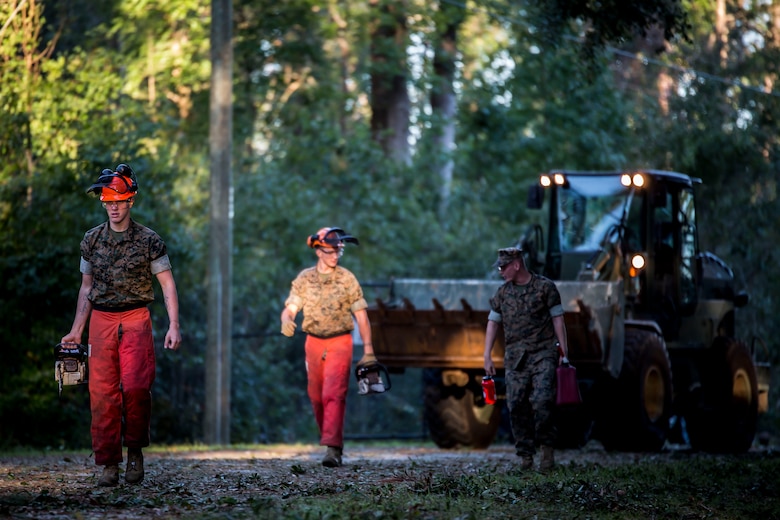 Marines carry equipment and fuel to clear debris on a road aboard Marine Corps Air Station Beaufort Oct. 9. Marines and sailors with MCAS Beaufort continued to work to remove debris and establish infrastructure aboard the air station and Laurel Bay after Hurricane Matthew. 