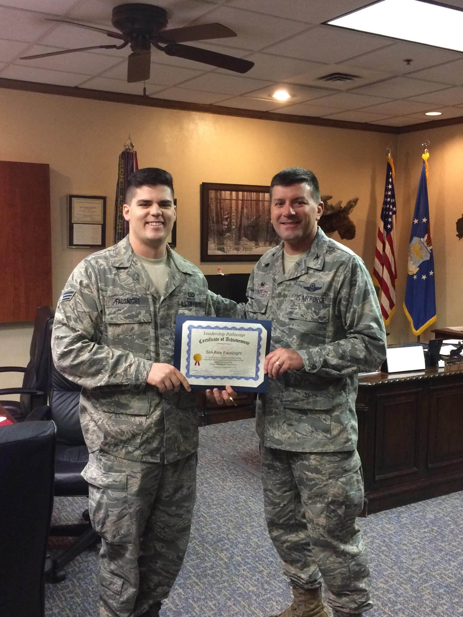 U.S. Air Force Col. Marty Reynolds, 55th Wing commander, presents Senior Airman Alex Fausnight, 338th Combat Training Squadron, with Team Offutt's first Gold Certificate awardee for Leadership Pathways.  Leadership Pathways is an Air Force program that Air Combat Command has adopted to help support the Comprehensive Airmen Fitness strategy.