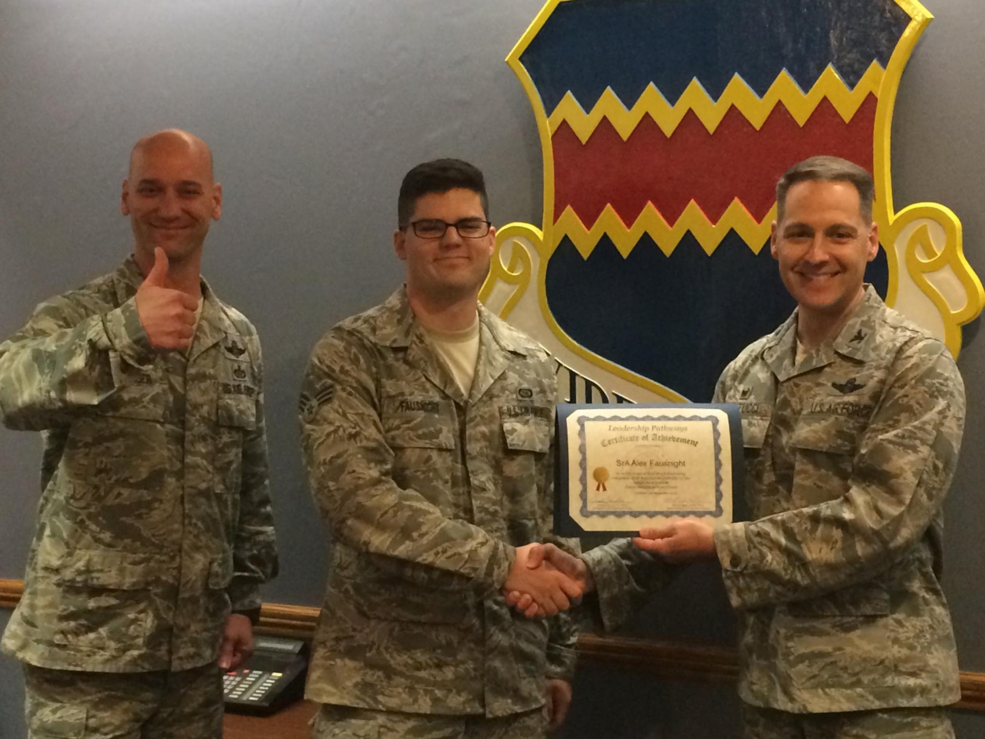 Air Force Col. Joseph Santucci, 55th Operations Group commander (right) and Air Force Chief Master Sgt. Michael Rager, 55th Operations Group command chief (left), present Air Force Senior Airman Alex Fausnight, 338th Combat Training Squadron (center), with his Gold Level certificate for Leadership Pathways. Leadership Pathways is an Air Force program that Air Combat Command has adopted to help support the Comprehensive Airmen Fitness strategy. (Courtesy Photo)