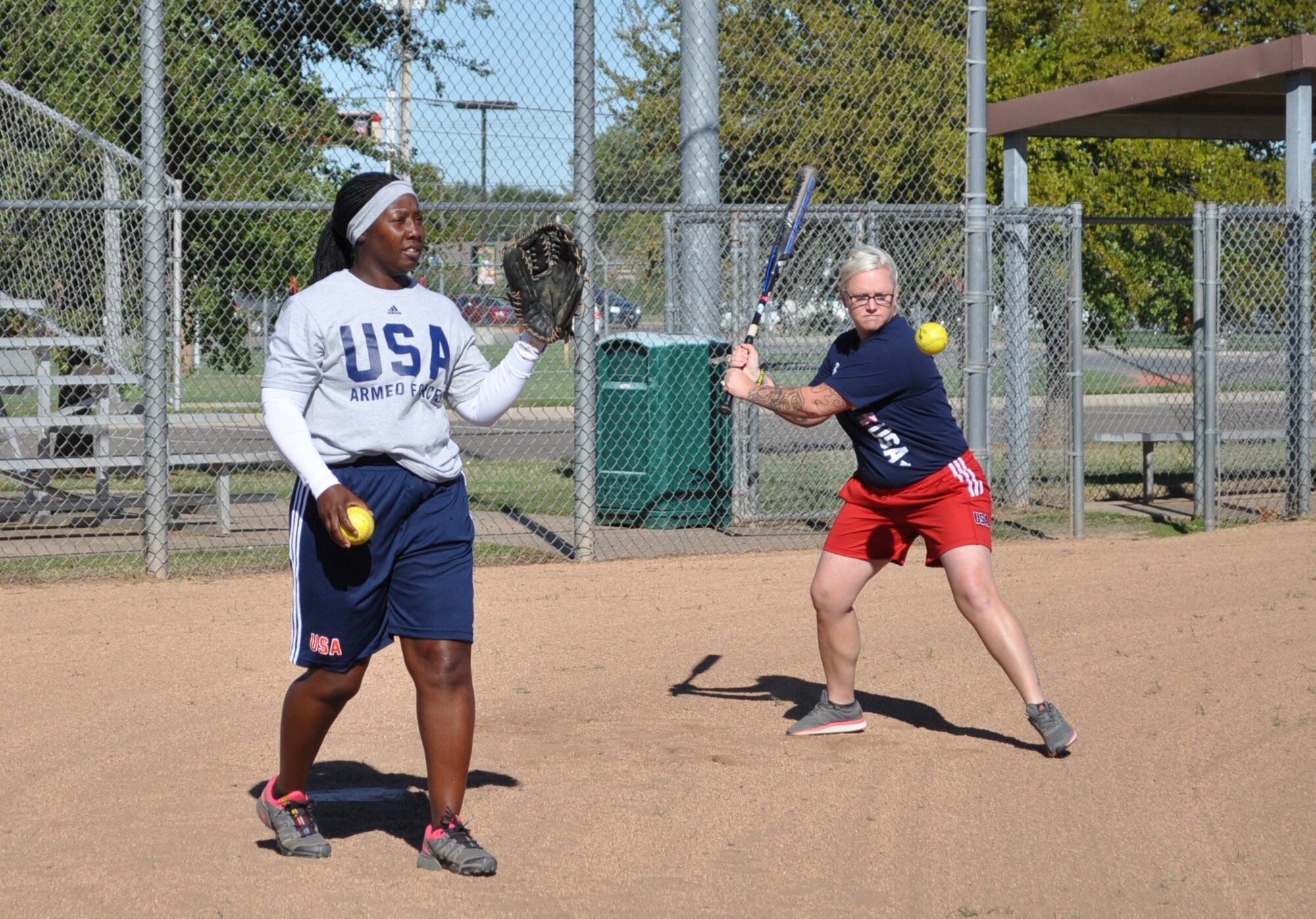 Niki Higgins, right, head coach of the women’s All-Armed Forces softball team, hits balls to infield players Sept. 29 during practice at Tinker Air Force Base’s Champ Field while utility player Schameka White catches incoming throws. The men’s and women’s All-Armed Forces softball teams stopped by before the Amateur Softball Association’s national championship tournament last weekend. (Air Force photo by John Parker)