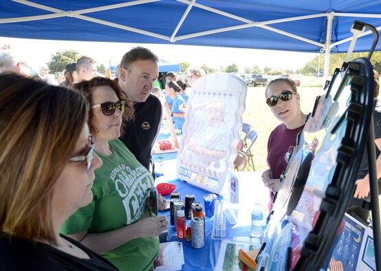 Laura Crowder, 72nd Medical Group Health Promotion manager, right, watches as participants in resiliency day activities spin the wheel to win a prize. (Air Force photo by Kelly White)