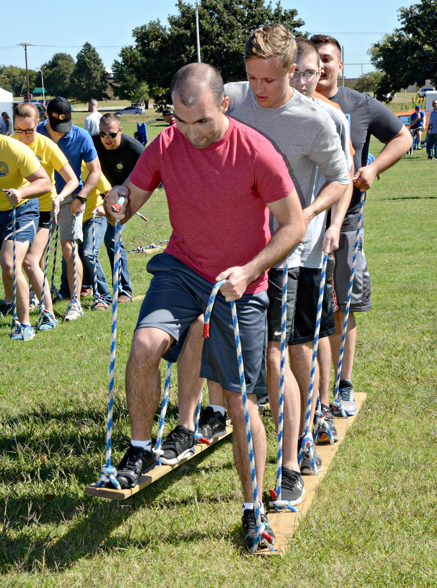 Several five-person teams participated in a fun obstacle course where they simultaneously walked on planks across the soccer field near the Airman Leadership School, then carefully walked or kangaroo-hopped another length of field with a softball between their knees. The next stretch, they piggyback-carried their teammates, until finally, they all spun around the heel of a baseball bat 10 times and ran the final stretch where a hot dog-eating contest finished it all off. The obstacle course was one of the fun activities for participants in Sports and Resiliency Day Sept. 30. Along with being able to get credit for resiliency training by participating in several activities, teams and individuals could also compete in bowling, corn hole, crud, golf, softball, basketball, volleyball and weight training tournaments or run in the 5K.  (Air Force photo by Kelly White)