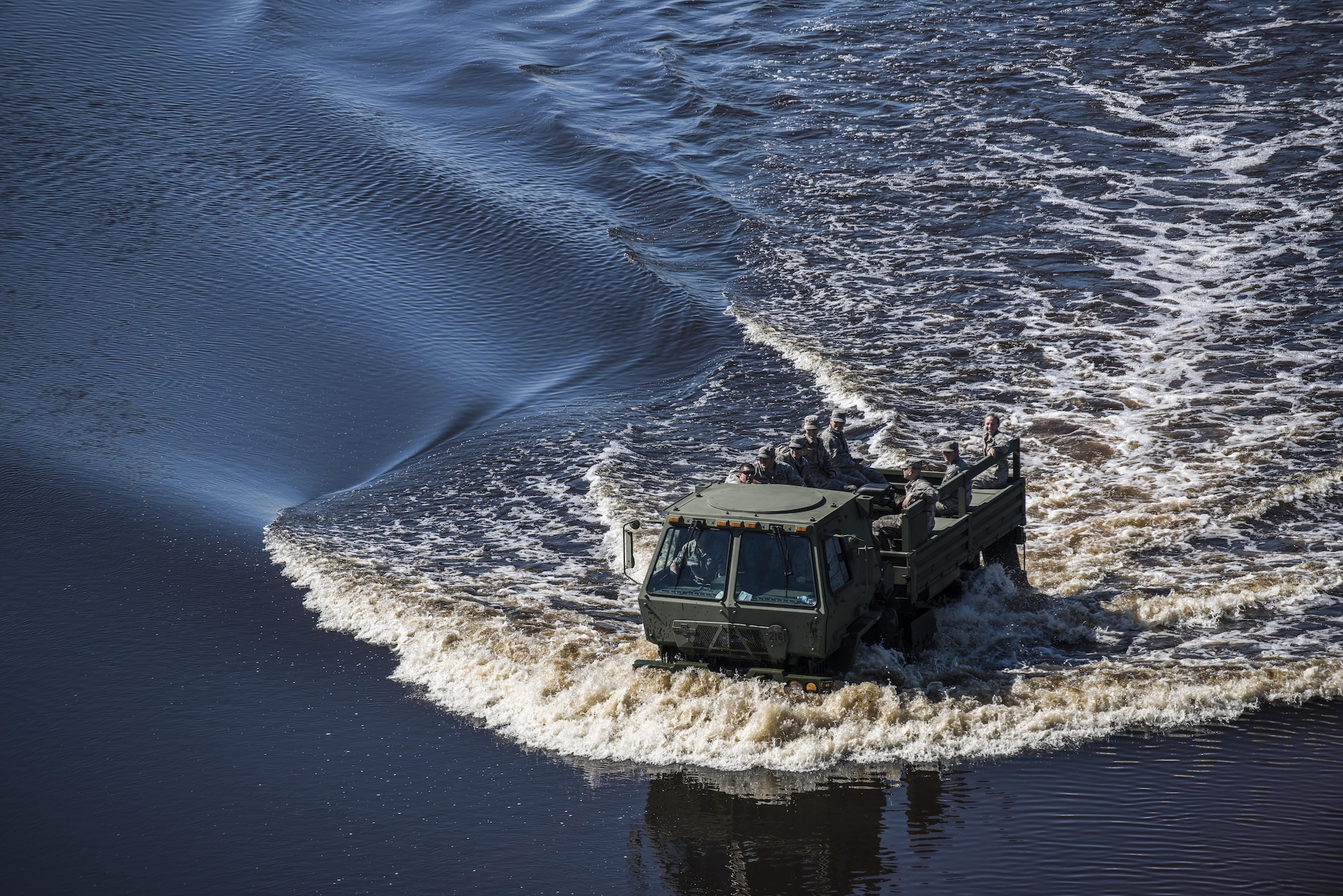 A crew of Airmen from the 4th Equipment Maintenance Squadron munitions flight drive onto the flightline through flood waters caused by Hurricane Matthew, Oct. 11, 2016, at Seymour Johnson Air Force Base, North Carolina. According to the National Weather Service, the Neuse River, located just outside the base perimeter, crested at a new record stage of 29.09 feet. (U.S. Air Force photo by Senior Airman Brittain Crolley)