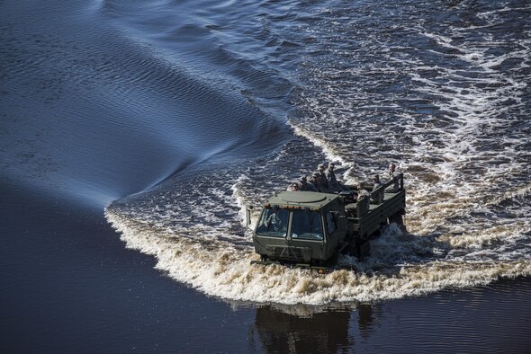 A crew of Airmen from the 4th Equipment Maintenance Squadron munitions flight drive onto the flightline through flood waters caused by Hurricane Matthew, Oct. 11, 2016, at Seymour Johnson Air Force Base, North Carolina. According to the National Weather Service, the Neuse River, located just outside the base perimeter, crested at a new record stage of 29.09 feet. (U.S. Air Force photo by Senior Airman Brittain Crolley)