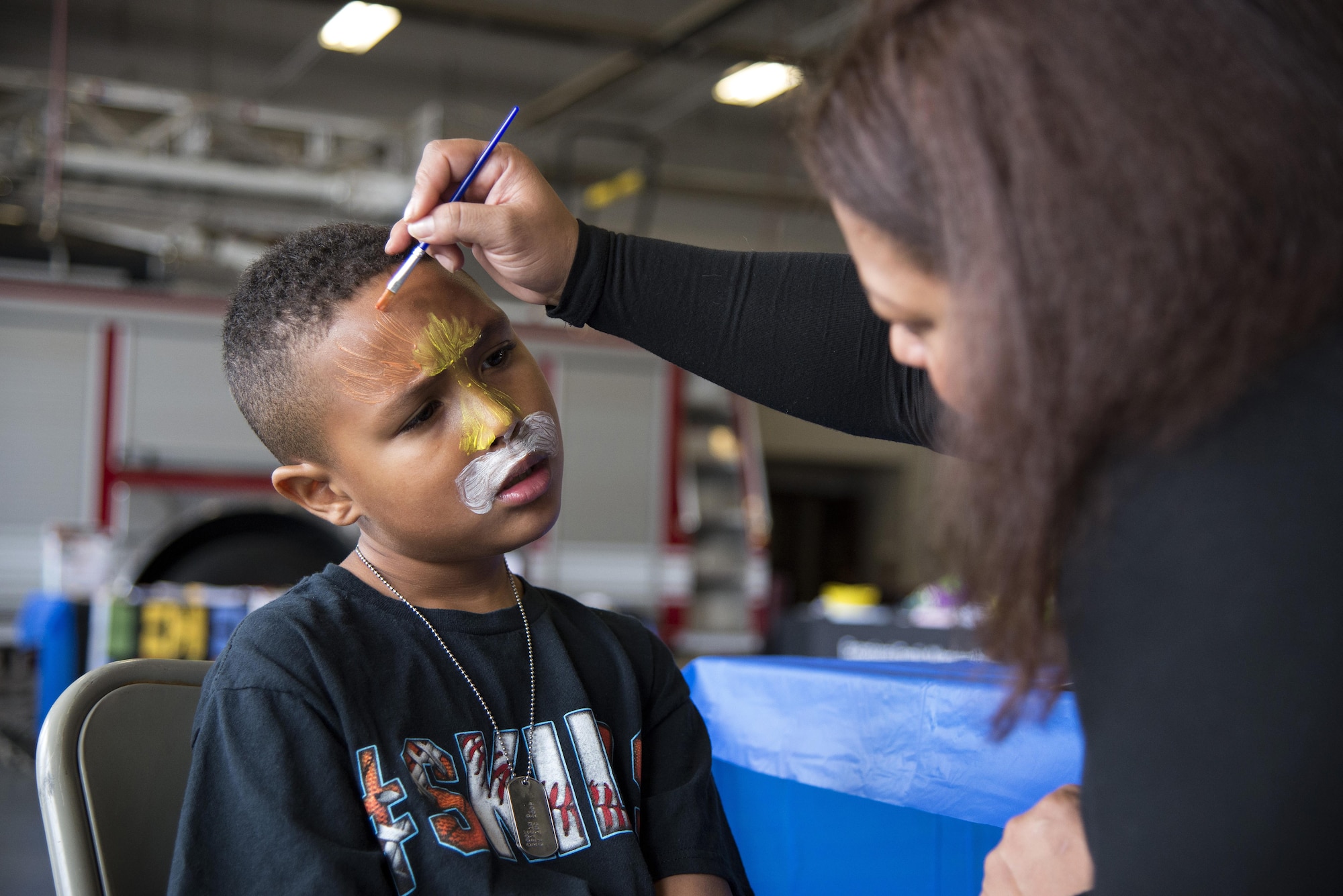 Staff Sgt. Dakota Lima, Armed Forces Medical Examiner System forensic toxicologist, paints the face of Reagan Cook, son of Tech. Sgt. Mandelyn Cook, 436th Logistics Readiness Squadron quality assurance evaluator, during the Dover Air Force Base First Responders’ Special Needs Day Oct. 8, 2016, at the 436th Civil Engineer Squadron Fire Department on Dover AFB, Del. The event featured face painting, information booths, several games and static emergency response vehicles available for tours. (U.S. Air Force photo by Senior Airman Aaron J. Jenne)