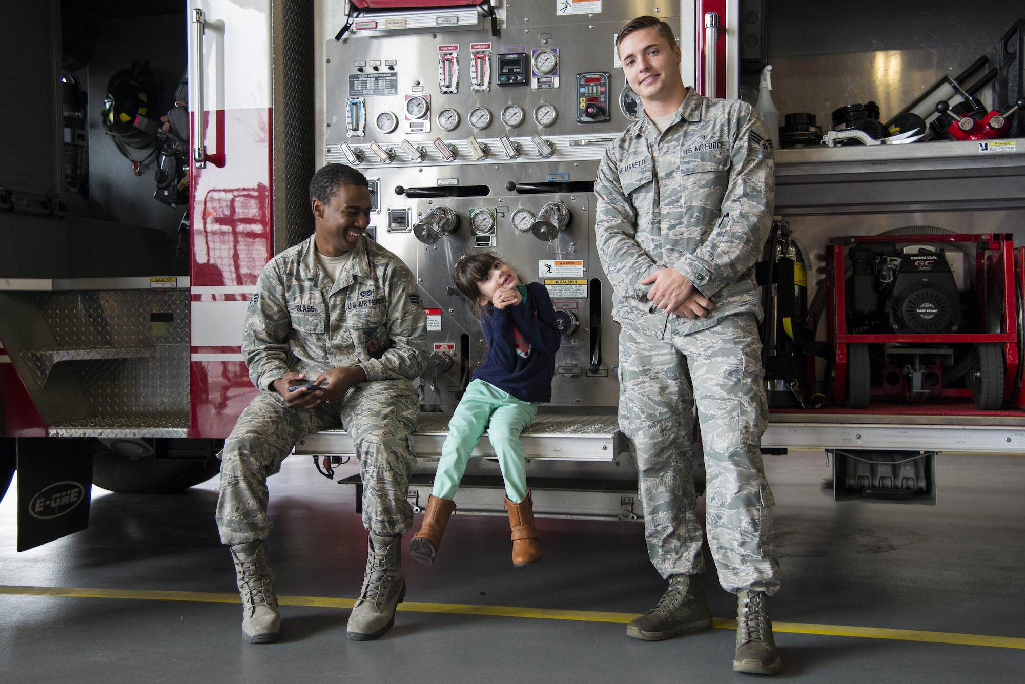 Senior Airman Marcus Glass, 436th Civil Engineer Squadron firefighter, and Senior Airman David Dejarnette, 436th Medical Group Ambulance Response Team medic, pose for a photo with Ashley Jones, daughter of Staff Sgt. Richard Ramirez, 436th Comptroller Squadron financial analyst, during the Dover Air Force Base First Responders’ Special Needs Day Oct. 8, 2016 at the 436th CES Fire Department on Dover AFB, Del. More than 20 members from Team Dover’s first response units, the Exceptional Family Member Program and School Liaison Office volunteered to assist with the event. (U.S. Air Force photo by Senior Airman Aaron J. Jenne)