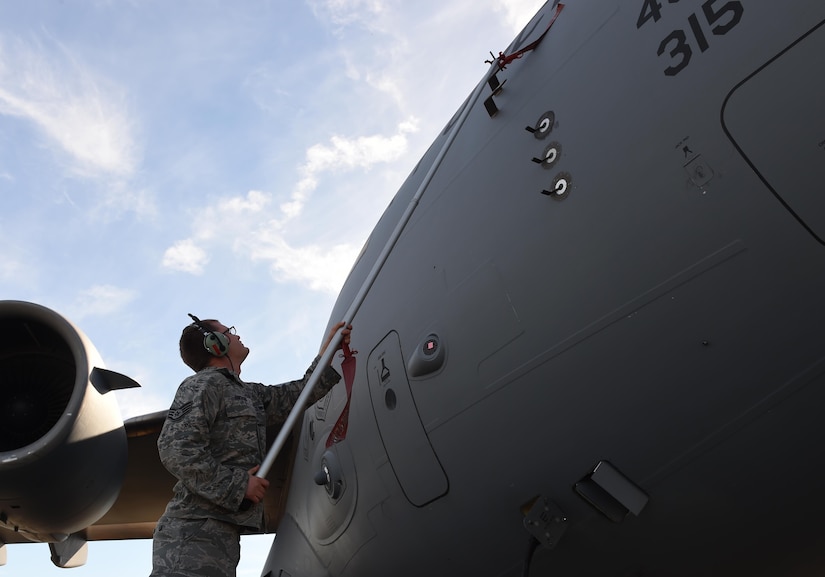 Staff Sgt. Kresten Erickson, 437th Aircraft Maintenance Squadron crew chief, place a “Remove before flight” flag to the first C-17 Globemaster III returning to Joint Base Charleston on Oct. 11 after evacuating for Hurricane Matthew. Maintenance crews worked extra hours to service aircraft before evacuating prior to the storm. 